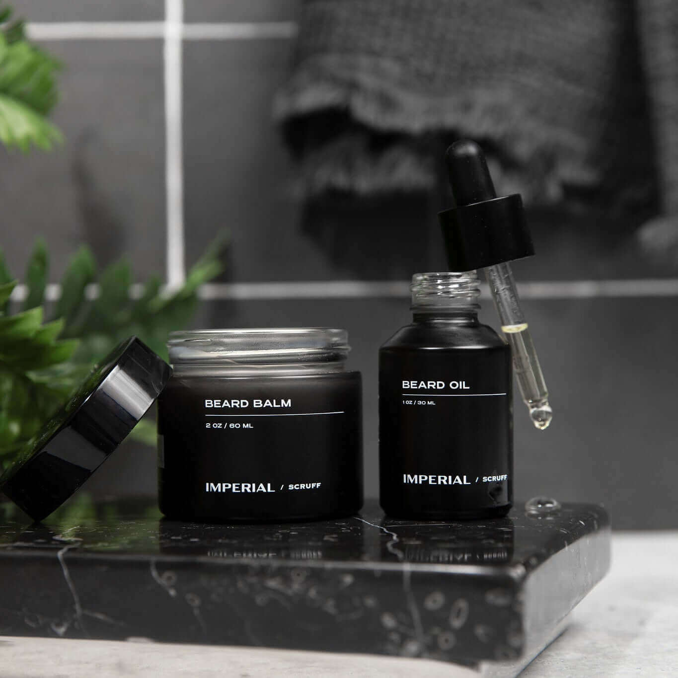 Imperial Scruff Beard care products including balm and oil on a black marble surface with a blurred background.