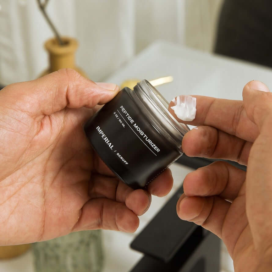 Person opening a black jar of face moisturizer.