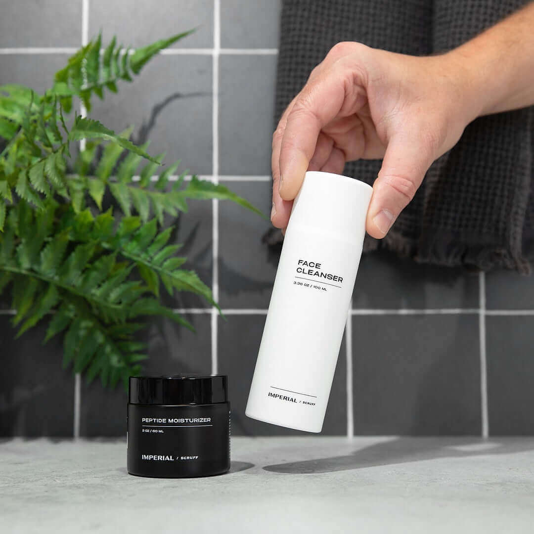Face cleanser and peptide moisturizer from Imperial Skincare on a white surface with a plant in the background.
