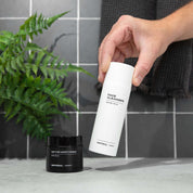 Face cleanser and peptide moisturizer from Imperial Skincare on a white surface with a plant in the background.