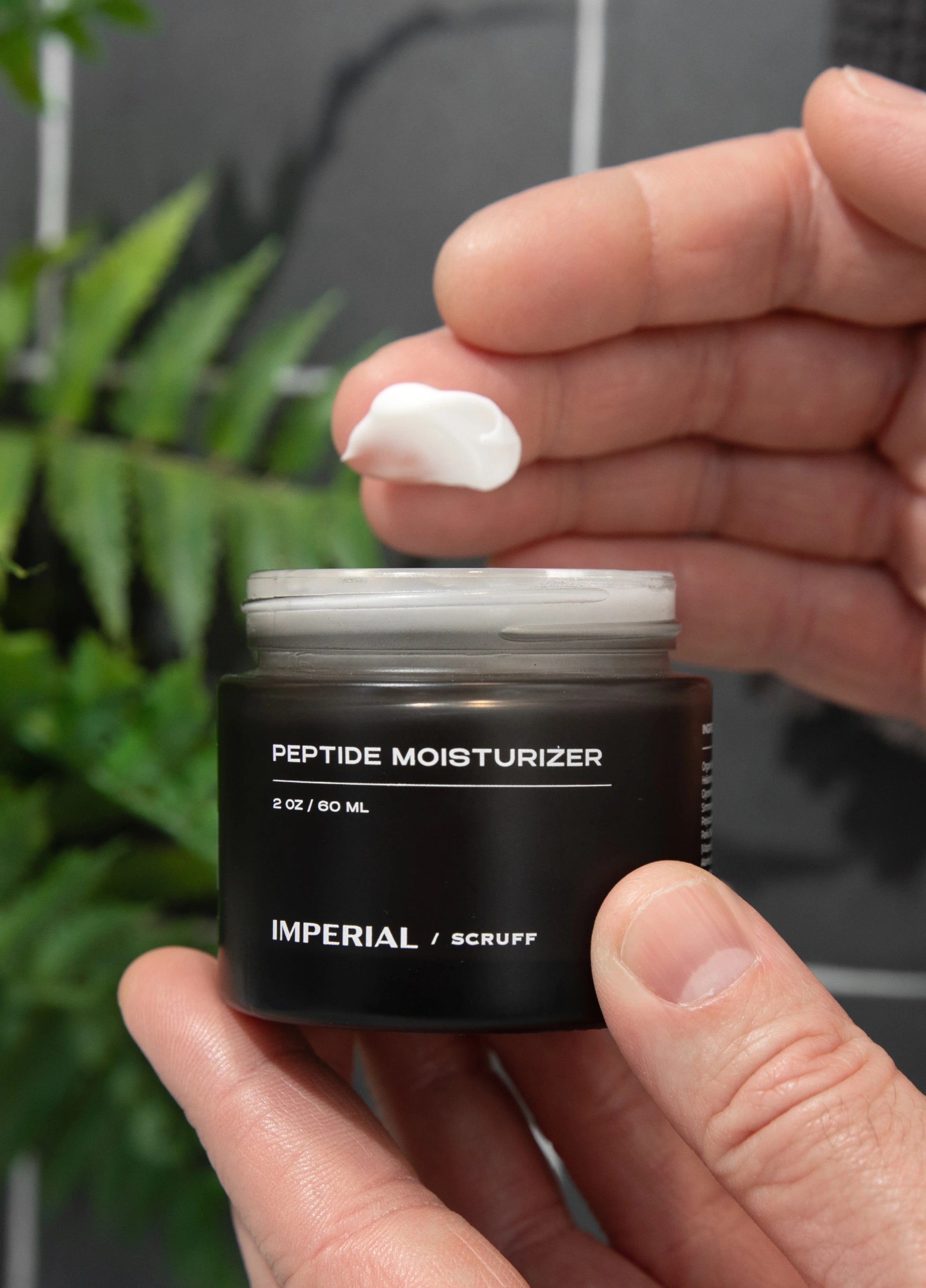 Imperial Scruff Peptide Moisturizer shown on man's finger