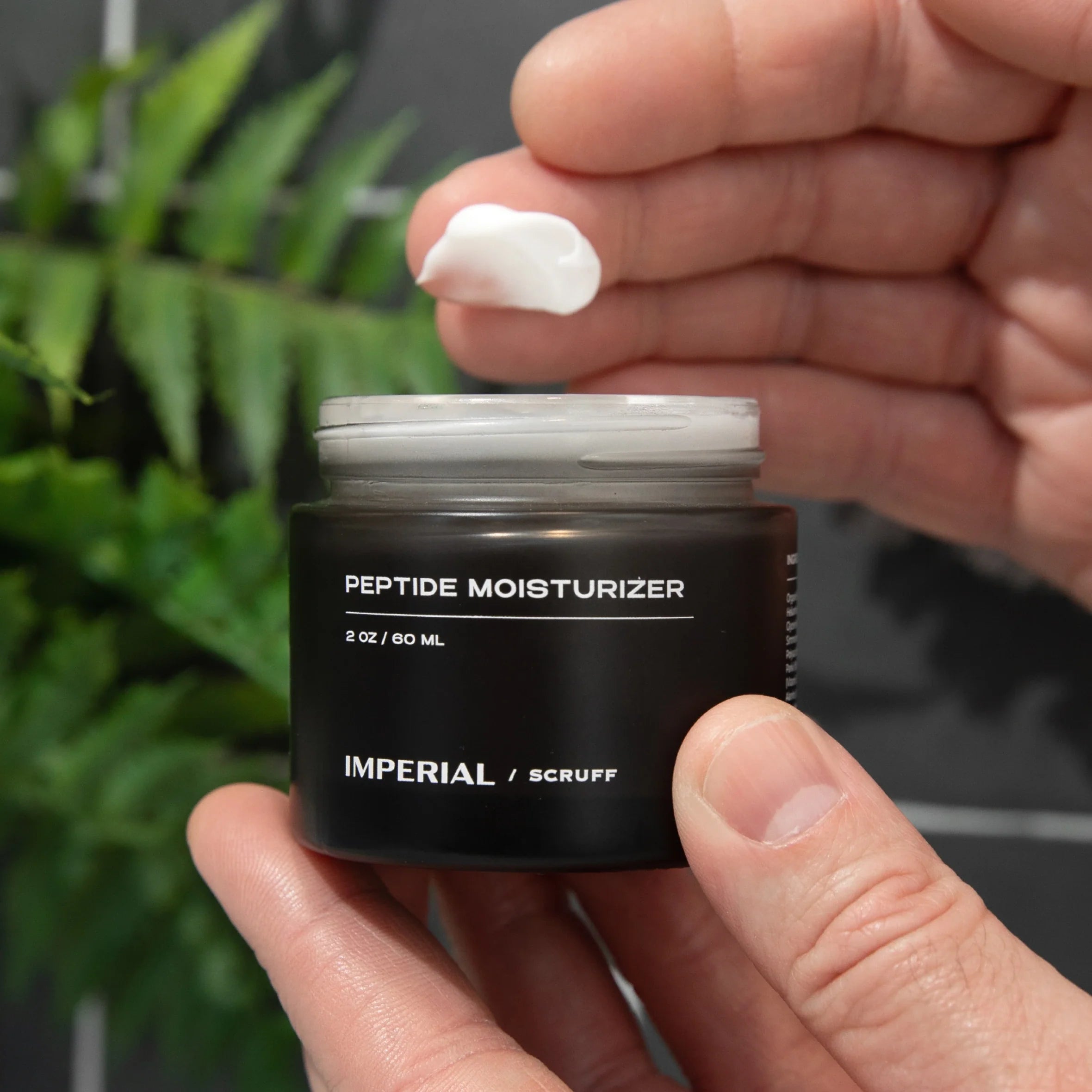 Peptide Moisturizer jar held by a hand, showcasing creamy texture for hydration and rejuvenation.